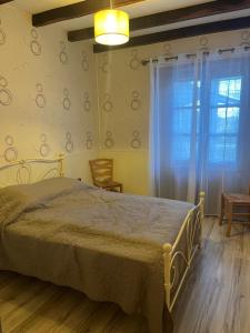 een slaapkamer met een groot bed en een raam bij CHARMANT LOGEMENT ENTIER A LA CAMPAGNE in Sencenac-Puy-de-Fourches