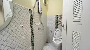 ein Bad mit einem WC und einer Dusche in der Unterkunft ที่พักสกลนครกรีนเฮ้าส์รีสอร์ท in Ban Na Oi