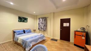 ein kleines Schlafzimmer mit einem Bett und einer Tür in der Unterkunft ที่พักสกลนครกรีนเฮ้าส์รีสอร์ท in Ban Na Oi
