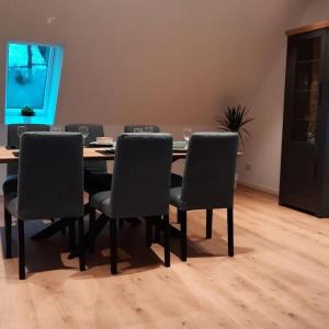 a dining room with a table and six chairs at Neubau Ferienwohnung - Wallsbüll in Wallsbüll