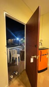 eine Tür zu einem Balkon mit einem Tisch und einem Stuhl in der Unterkunft ที่พักสกลนครกรีนเฮ้าส์รีสอร์ท in Ban Na Oi