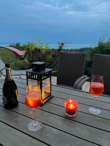 - deux verres de vin et des bougies sur une table en bois dans l'établissement Ágnes Panoráma Háza, à Révfülöp