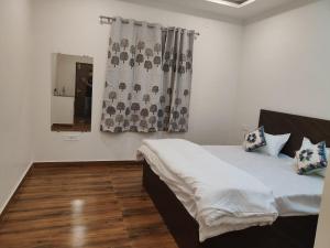 1 dormitorio con cama y ventana en Uma Magan Farms, en Vrindāvan