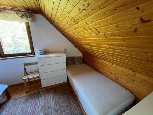 een kleine kamer met een bed en een raam bij Ágnes Panoráma Háza in Révfülöp
