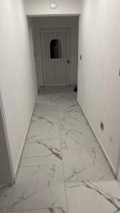 um corredor vazio com piso em mármore e uma porta em Hajredinovic Villa em Saraievo