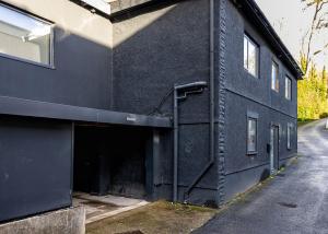 a black building with a large entrance to a garage at Libra House retreat, Caswell Bay in Swansea