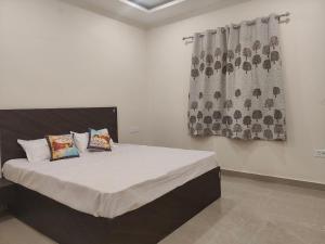 a bedroom with a bed with two pillows and a window at Uma Magan Farms in Vrindāvan