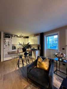 a living room with a couch and a kitchen at romslig leilighet til leie in Arendal