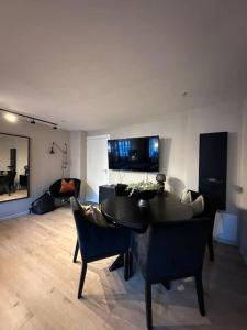a living room with a black table and chairs at romslig leilighet til leie in Arendal