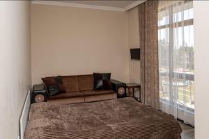 um quarto com uma cama, um sofá e uma janela em Hotel Luka em Ureki