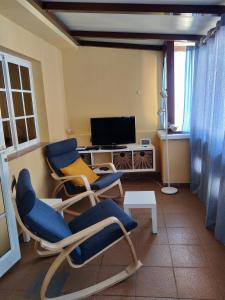 a living room with two chairs and a television at Dachterrassenwohnung Puerto Tazacorte in Puerto