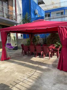 czerwony namiot ze stołami i krzesłami pod nim w obiekcie Hotel Luka w mieście Ureki