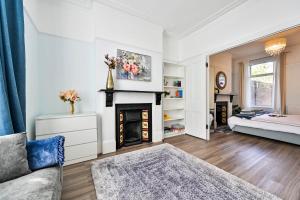 a living room with a fireplace and a couch at Greenwich Holiday Home in London