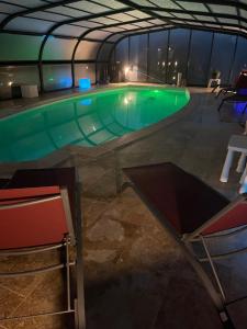 a swimming pool with green water in a building at Studio spa privé accès piscine in Moëlan-sur-Mer