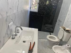 La salle de bains blanche est pourvue d'un lavabo et de toilettes. dans l'établissement Casa Monte, à Monte Hermoso