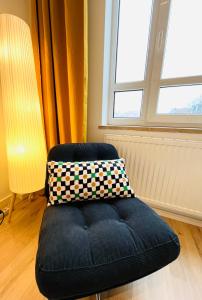uma cadeira com uma almofada em cima dela em frente a uma janela em D52 - das Businessapartment em Dresden