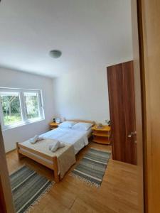 1 dormitorio con 1 cama y puerta de madera en Guest house Green River, en Ljubuški