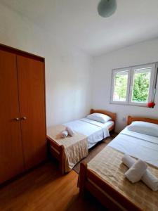 1 dormitorio con 3 camas y ventana en Guest house Green River, en Ljubuški