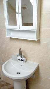 - Baño con lavabo blanco y armario en Studio Flat 3 Nelson Town Centre en Nelson