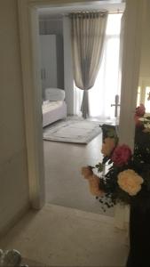 Habitación con espejo y ventana con flores en DIELL HOTEL, en Durrës