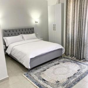 1 dormitorio con 1 cama blanca grande y 1 alfombra en DIELL HOTEL, en Durrës