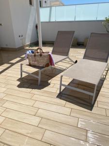 two benches and a basket on a tile floor at Casalura in Polignano a Mare