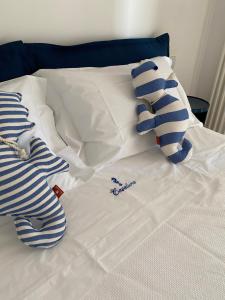 a bed with white sheets and two stuffed teddy bears at Casalura in Polignano a Mare