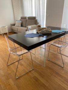 a black table with three chairs and a couch at Casalura in Polignano a Mare