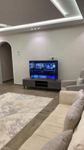 a living room with a flat screen tv on a wall at Retal Hotel Apartments in Taif