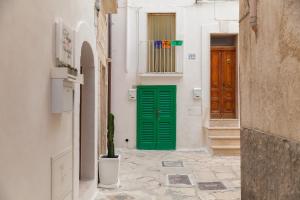 a narrow alley with a green door and a cactus at Palazzo Fiscaiolo in Monopoli