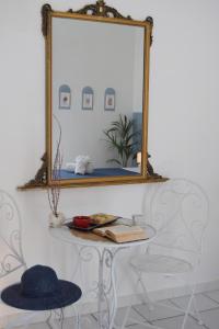 uno specchio su un muro sopra un tavolo con un cappello di Casetta nel centro storico a Mattinata