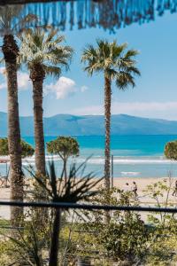 a view of a beach with palm trees and the ocean at Mustafa Suites in Vlorë