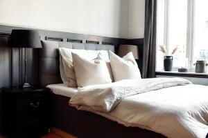 a bedroom with a bed with white sheets and pillows at Oslo Vest in Oslo