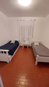 1 dormitorio con 2 camas y lámpara. en Depto 9 de Julio en Concepción del Uruguay