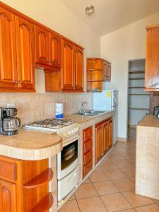 uma cozinha com armários de madeira e um forno com placa de fogão em Ritz Empress em San Juan del Sur