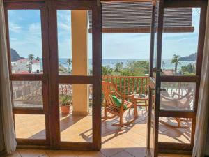 een open deur naar een balkon met een tafel en stoelen bij Ritz Empress in San Juan del Sur
