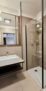 a bathroom with a sink and a shower with a mirror at HOLIDAY HOME Bel Mare 317e z balkonem in Międzyzdroje