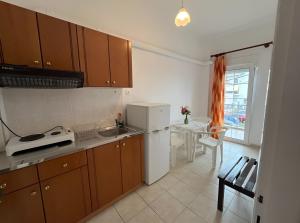 una cucina con lavandino, frigorifero e tavolo di Chrysa Rooms a Leptokarya