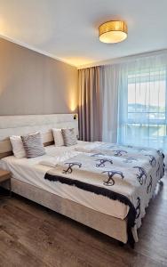 a bedroom with a large bed with a large window at HOLIDAY HOME Bel Mare 317e z balkonem in Międzyzdroje