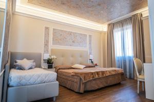 モンテカティーニ・テルメにあるHotel Ariston & Spaのベッドルーム1室(ベッド2台、ソファ付)