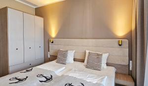 a bedroom with two beds with white sheets and pillows at HOLIDAY HOME Bel Mare 317e z balkonem in Międzyzdroje