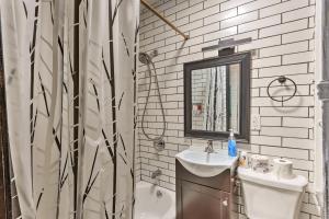a bathroom with a shower and a sink and a mirror at 1850s historic Row House 7min train to NYC with private backyard in Jersey City