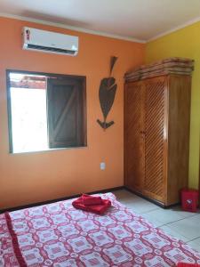 a bedroom with a bed and a window and a window at Pousada Estrela Feliz in Canavieiras