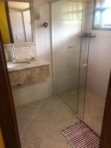 een badkamer met een glazen douche en een wastafel bij Pousada Estrela Feliz in Canavieiras