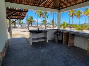 an outdoor kitchen with a view of the beach at Pousada Estrela Feliz in Canavieiras