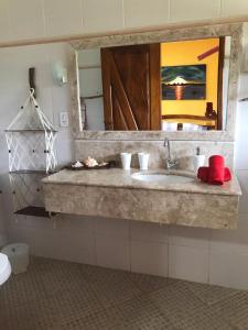 a bathroom counter with a sink and a mirror at Pousada Estrela Feliz in Canavieiras