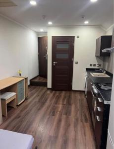 a kitchen with wooden floors and a wooden door at Unique Studio Flat in City Center in Leicester