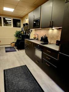 a kitchen with black cabinets and a living room at Base apartments - capital area in Hafnarfjörður