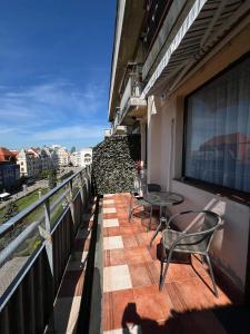 a balcony with chairs and tables on a building at City Center View Studio Apartment 1 in Timişoara