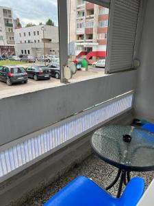 una mesa y una mesa de cristal en una habitación con ventana en Aurum 29a, en Doboj